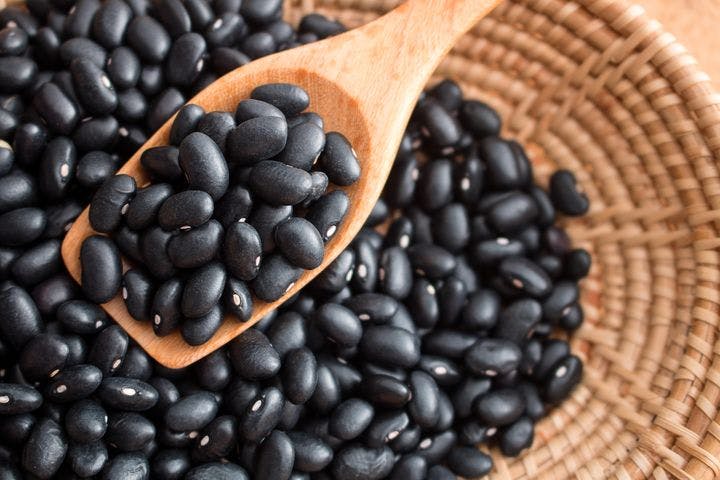 A close-up shot of a spoon of black beans