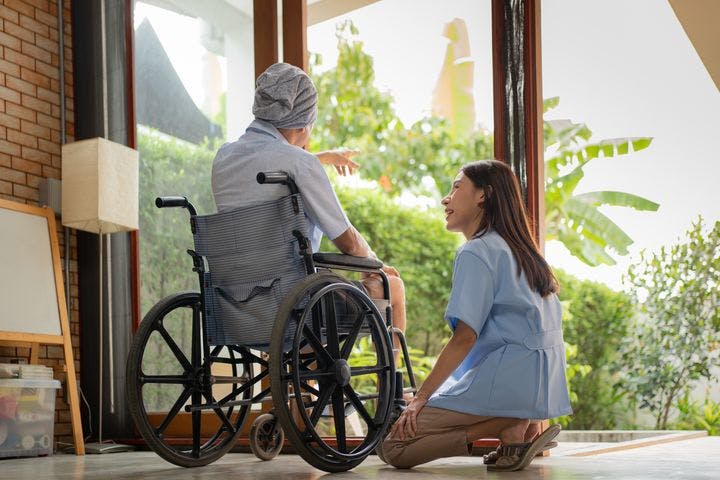 Asian nurse tending to an elderly cancer patient.
