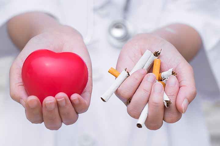 Person holds out one hand holding toy heart and other hand holding cigarettes