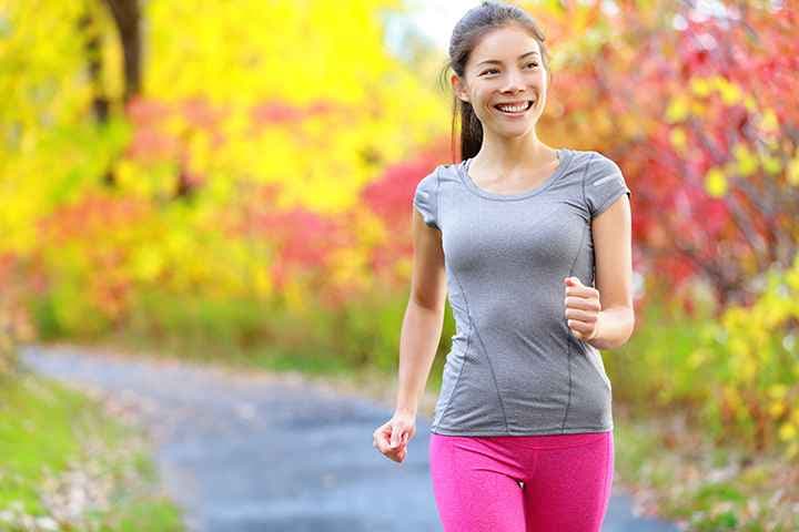 Woman power walking through a park trail