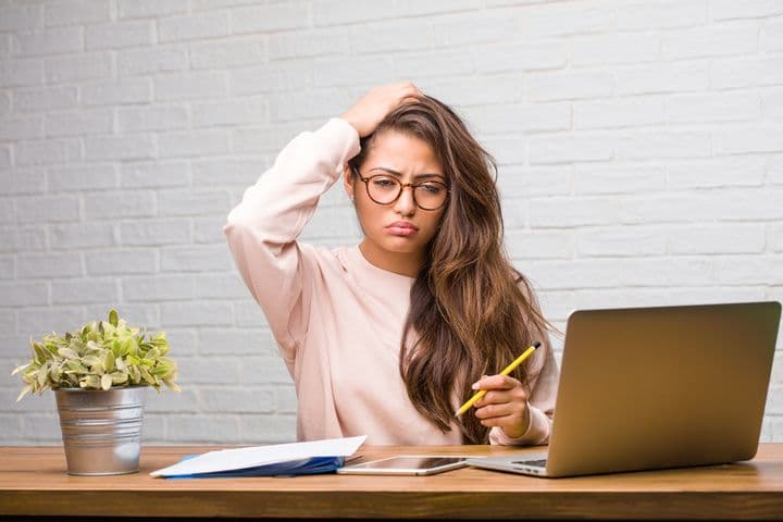 Girl working in front of laptop looking confused