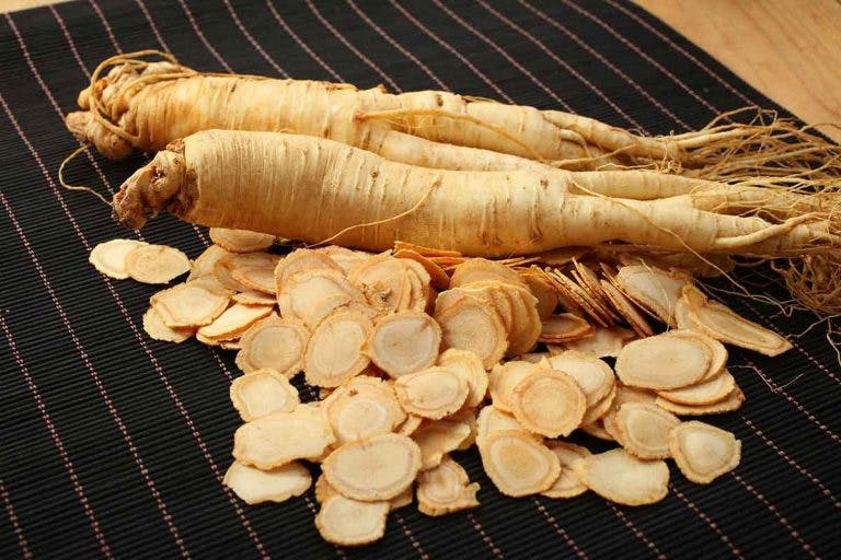 American ginseng root and slices displayed on a bamboo mat