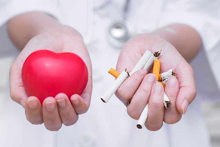 Person holds out one hand holding toy heart and other hand holding cigarettes