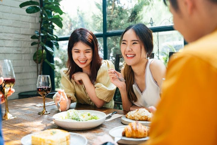 Two women enjoying a meal with friends