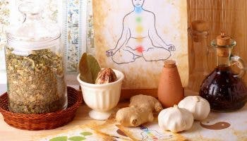 Natural ingredients, herbs, and an illustration of a man with chakras on a table