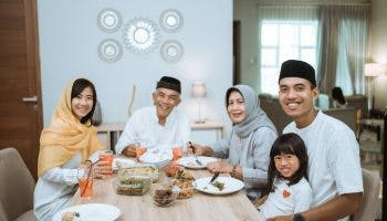 Muslim family at dinning table eating a meal