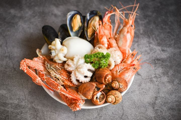 A plate of various shellfish displayed on a grey granite surface