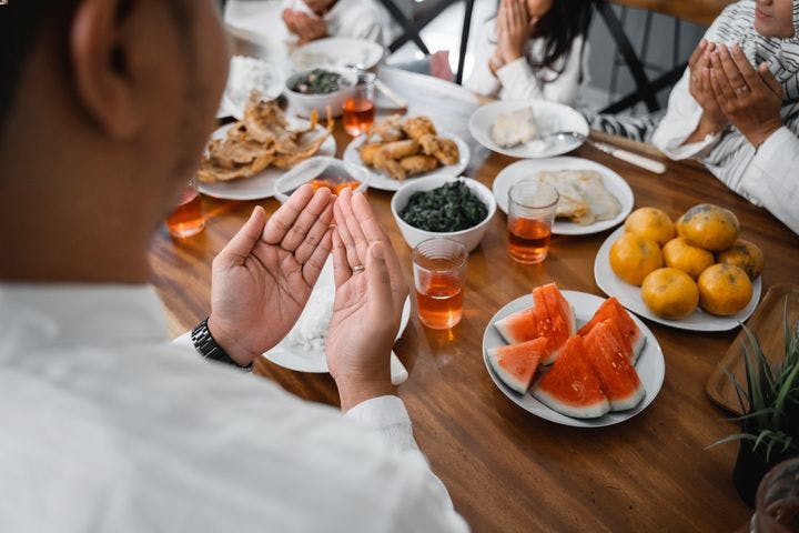 A Muslim man praying and food on the table