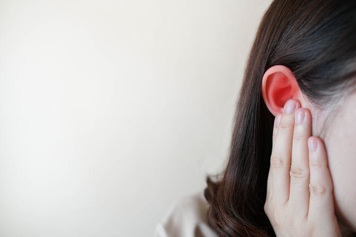 Woman holding her right ear in pain with her right hand