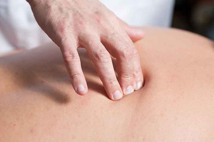 A physician putting pressure on an acupressure point to release tension