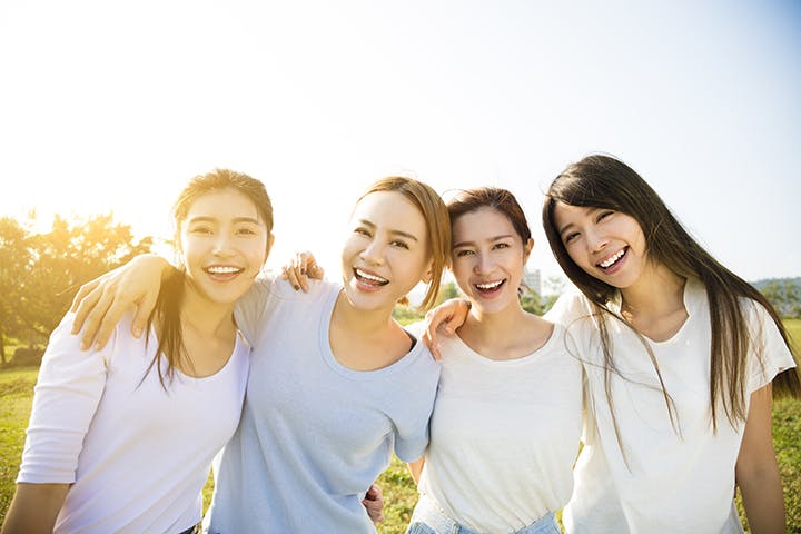A group of four women outdoors, smiling