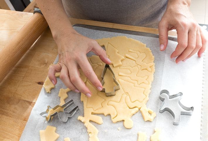 Woman cutting pastry into different shapes using a metal shaped cutter