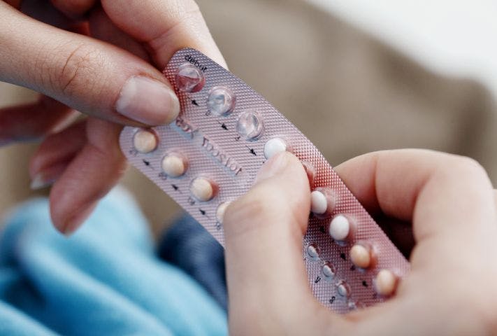 A woman taking a daily birth control pill