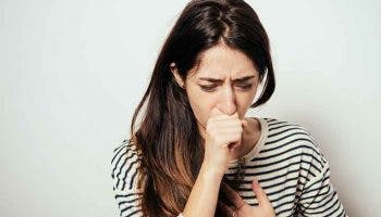A girl coughing into her closed palm