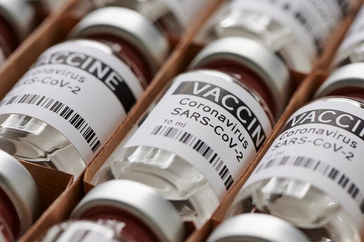 A close-up shot of columns of ampoules, labelled with “VACCINE - Coronavirus SARS-CoV-2”.