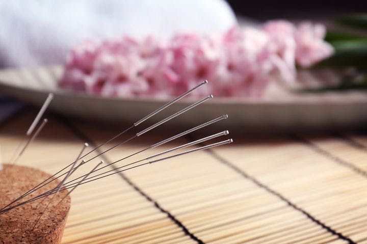 Closeup of acupuncture needles inserted into a cork