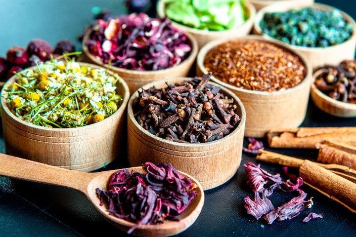 Dried tea leaves of many colours in a wooden bowl 