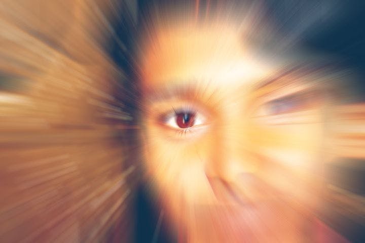 Motion blur close-up of a woman’s right eye as she looks up 