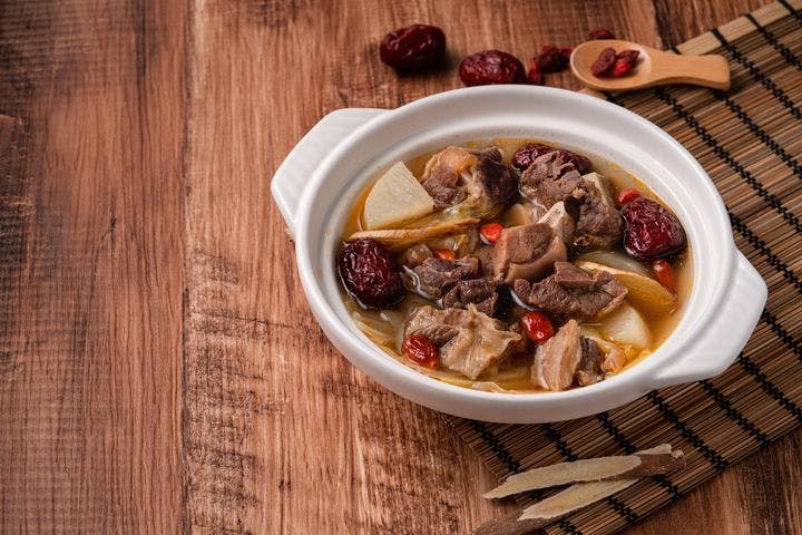 Fresh delicious mutton hot pot with vegetables and Chinese herbal medicine like goji berry and Chinese angelica dang gui