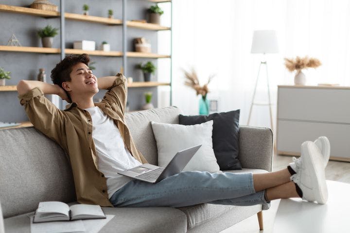 Young Asian man relaxing on a sofa at home