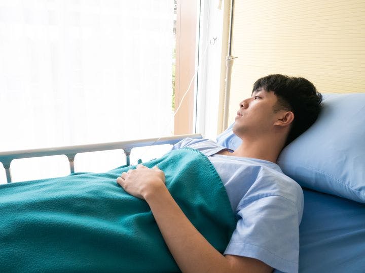 Asian man resting in a hospital bed