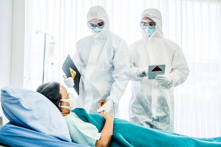 Patient on a bed being attended to by doctors.