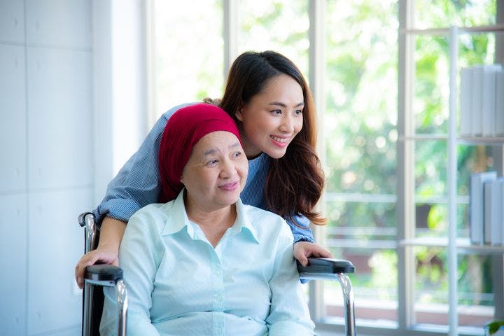 Asian daughter with mother on wheelchair.