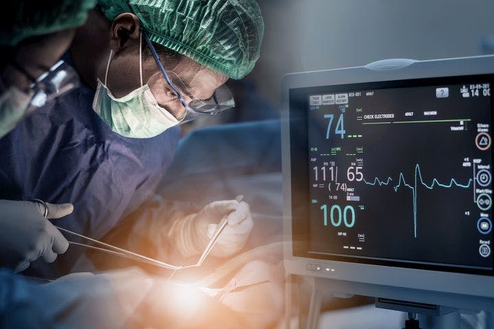 Surgery being performed with a monitor showing the heart parameters.