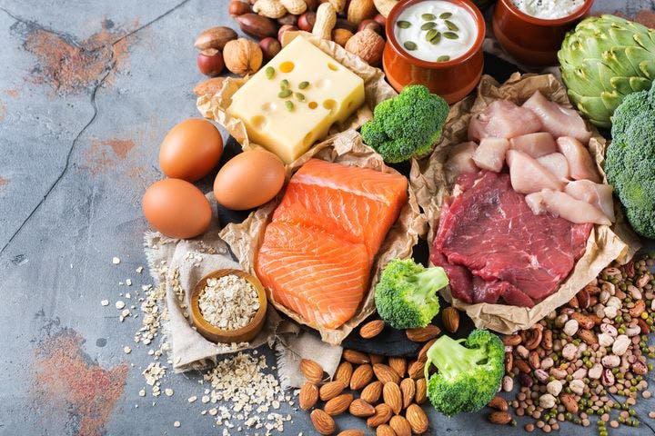 An assortment of protein-rich foods displayed on a concrete surface.