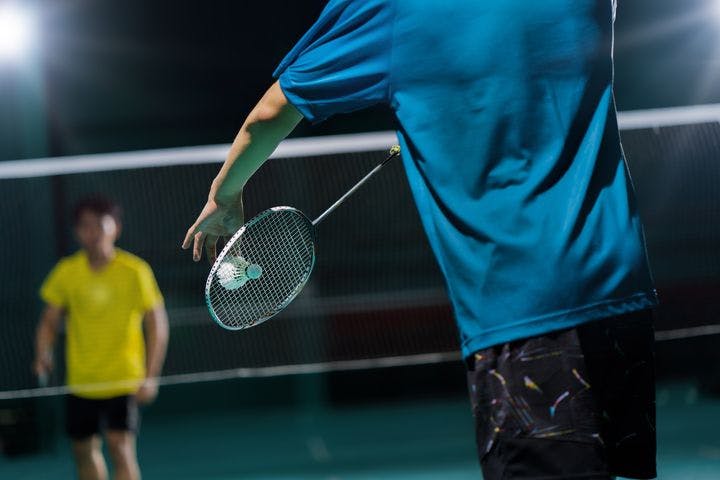 Two men playing badminton.