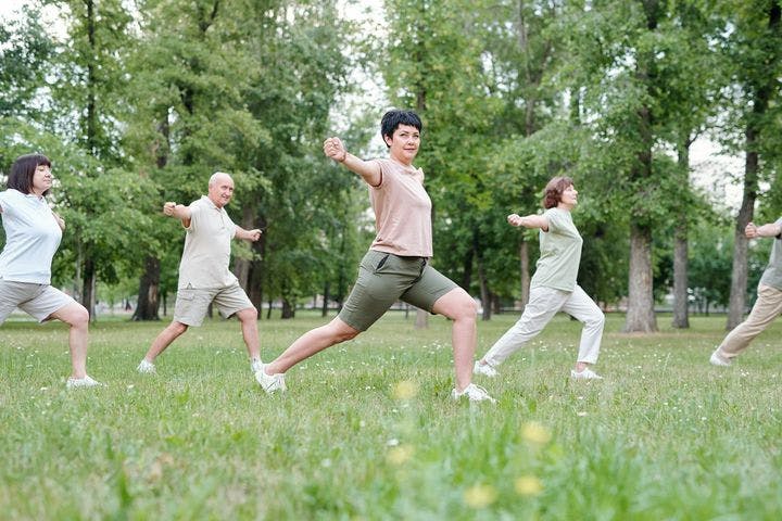 A group of people practising Qigong in a park. 