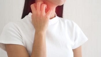 Woman scratching her neck with her right hand.