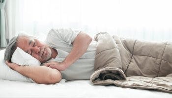 Older man lying in bed sleeping.