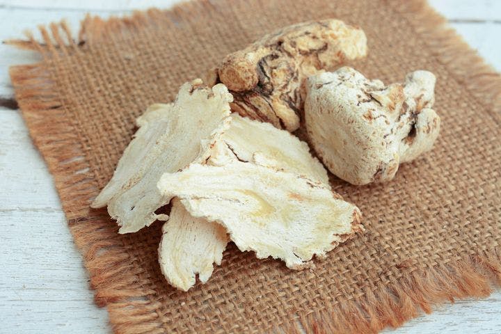 Whole and sliced Angelica sinensis on a woven mat