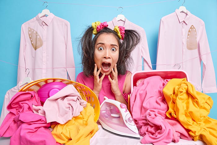 A woman screams with shock seeing the large amount of laundry piled up in around her 
