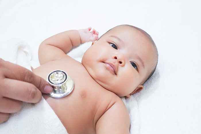 Baby lying down with a stethoscope on its chest