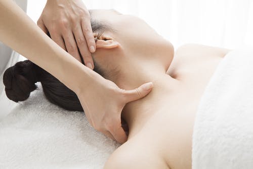 A close-up shot of a woman getting a neck massage