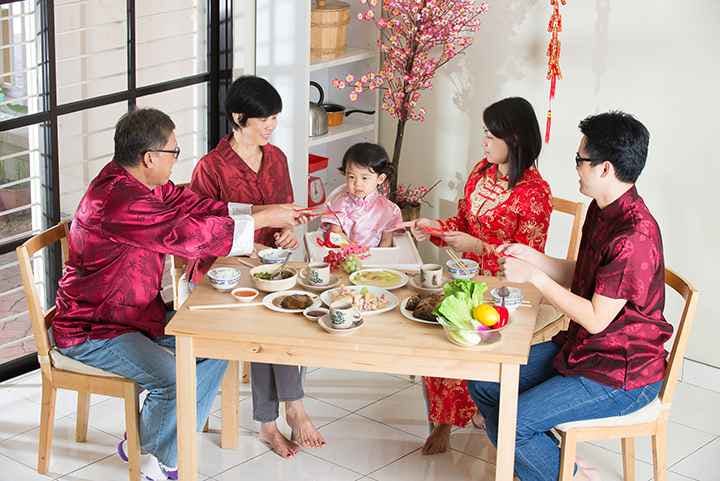 A family sitting together at the dining table for their Chinese New Year reunion dinner