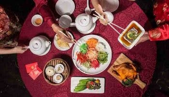 A Chinese New Year meal comprising a variety of dishes and Yee Sang