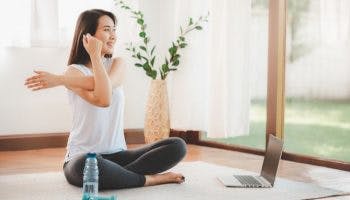Woman sitting at desk taking a break from work and doing a neck stretch