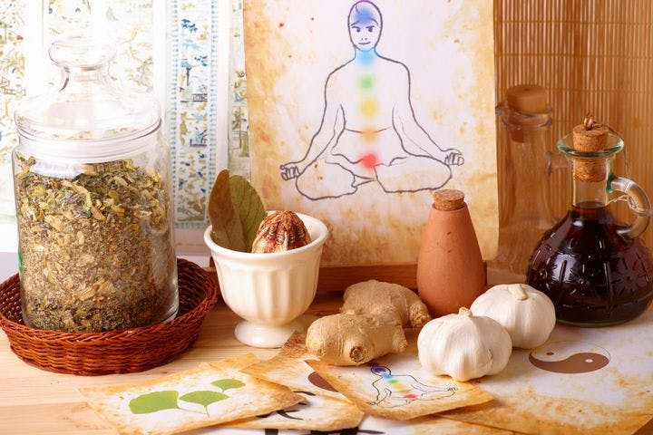 Natural ingredients, herbs, and an illustration of a man with chakras on a table