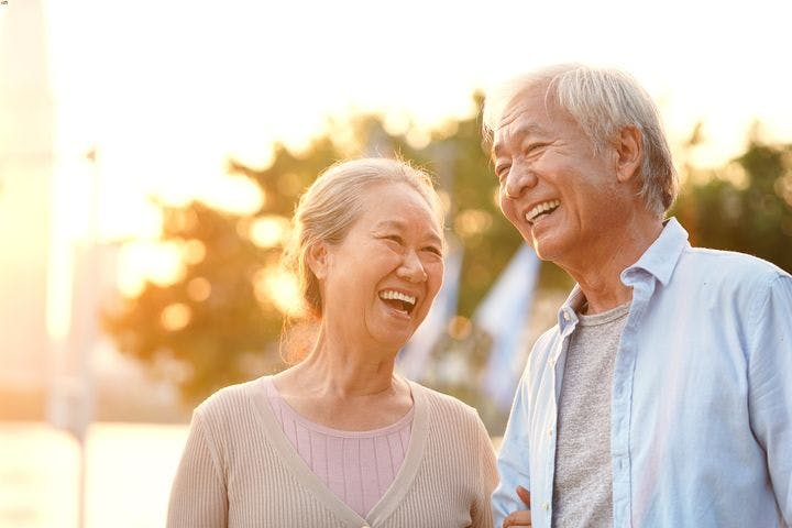 Elderly couple laughing together while being outdoors