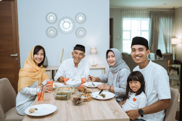 Muslim family at dinning table eating a meal