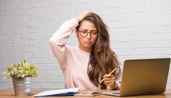 Girl working in front of laptop looking confused