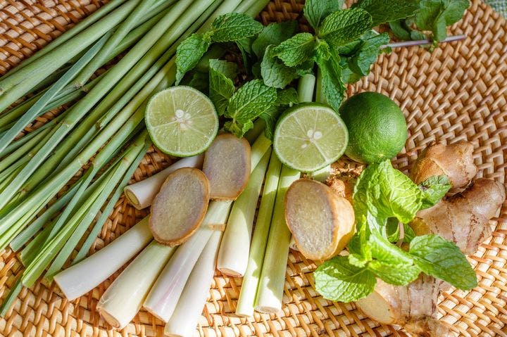 Fresh lemongrass, ginger, mint, and lime in a basket