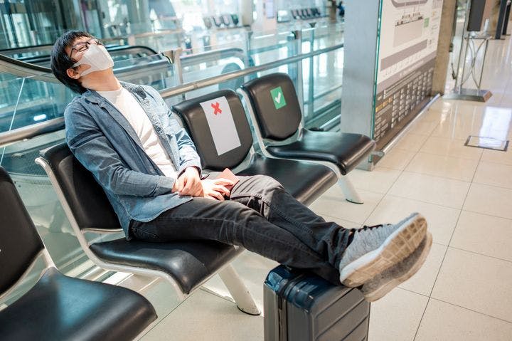 A man sleeping while sitting in an airport waiting room