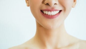 Closeup of a young, smiling woman’s beautiful teeth due to good oral hygiene