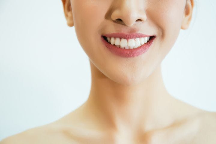 Closeup of a young, smiling woman’s beautiful teeth due to good oral hygiene