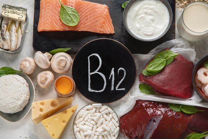 Circular sign that reads “B12” surrounded by different sources of vitamin B12 on a white background