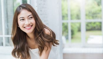 A close-up photo of a beautiful Asian woman with a V-shape face, smiling